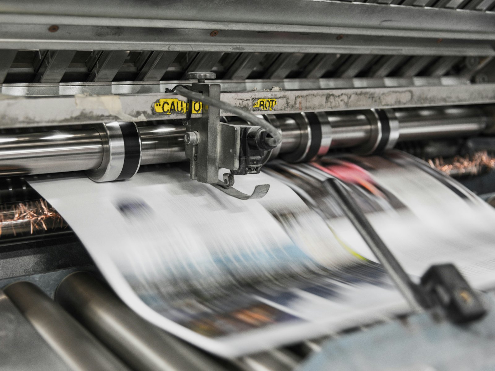 Sheets running through a four-colour press mid-production