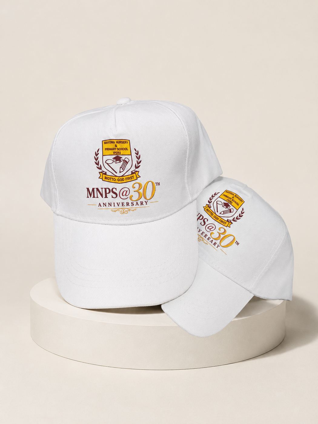 Two embroidered white caps marking the 30th anniversary of Mayowa Nursery and Primary School, Iperu